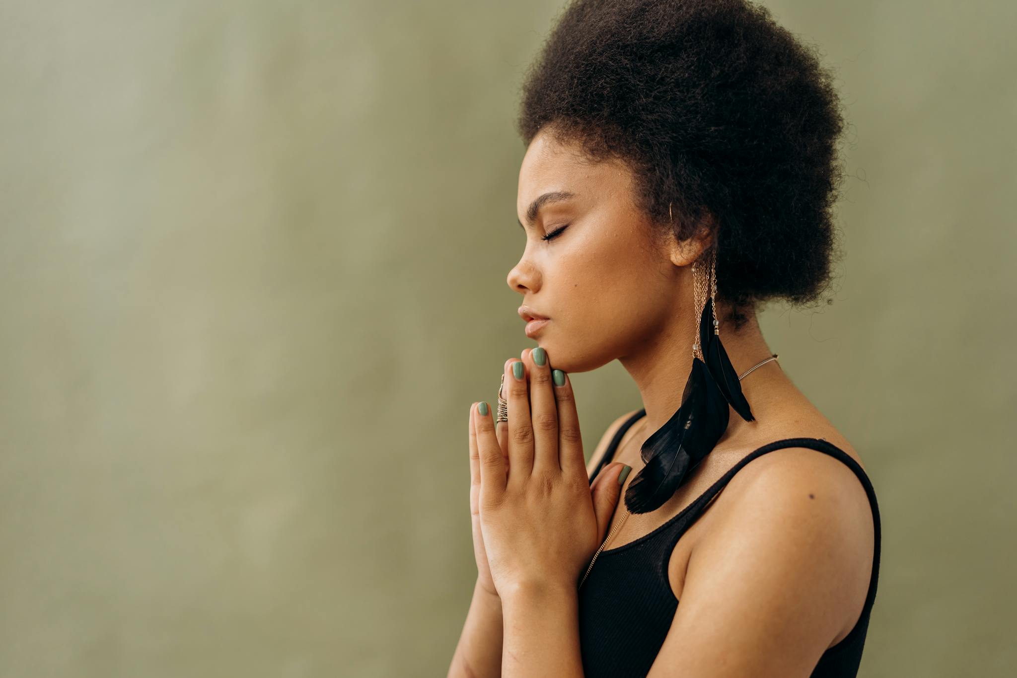 Home A young woman with afro hair practicing calming meditation indoors.
